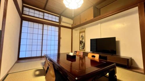a living room with a table and a television at Private Rental 1 Minute Walk to the Sea 隠れ宿 波風の音 小田原の1棟貸切旅館 海まで徒歩1分 in Odawara