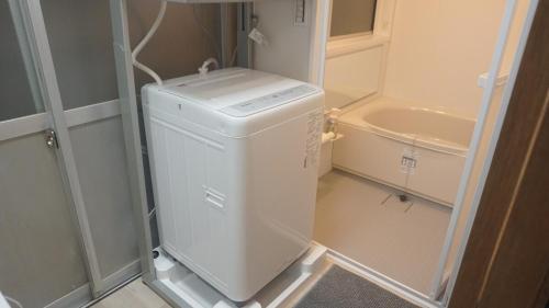 a white washer and dryer in a small bathroom at Private Rental 1 Minute Walk to the Sea 隠れ宿 波風の音 小田原の1棟貸切旅館 海まで徒歩1分 in Odawara