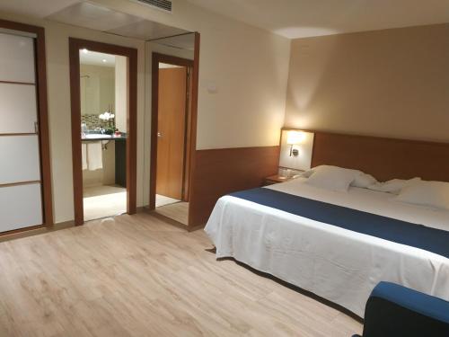 a hotel room with a bed and a mirror at Hotel RH Sorolla Centro in Valencia