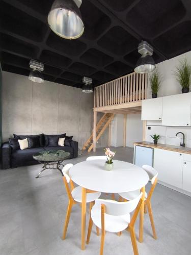 a living room with a white table and chairs at Apartament Antresola in Ostróda