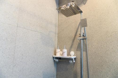 a shower in a bathroom with a shower head at Ada Villa in Panji
