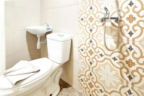 a bathroom with a toilet and a sink at Urbanview Hotel Omah Anin Batu by RedDoorz in Tlekung