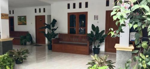 a lobby with wooden doors and potted plants at Griya Kulon Yogya in Jetis