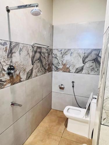 a bathroom with a toilet and a shower at Dwaraka Resorts in Tiruvannāmalai