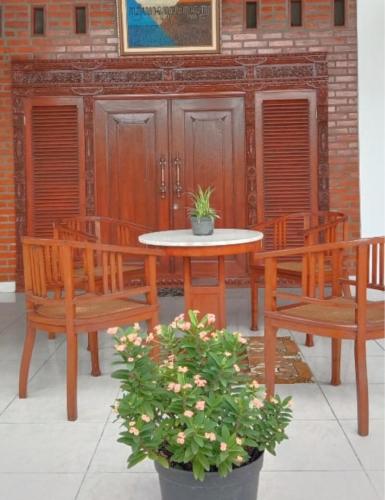 a table and two benches and a table and chairs at Griya Kulon Yogya in Jetis