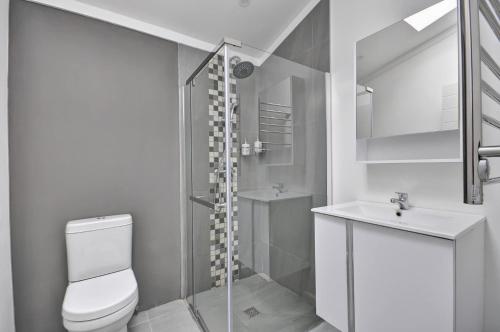 a bathroom with a toilet and a shower and a sink at Lorelei Guest House in George