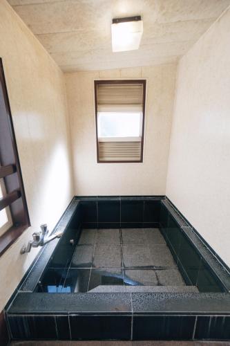a bath tub in a room with a window at DokiDoggie城ヶ島遊ケ崎BASE in Miura
