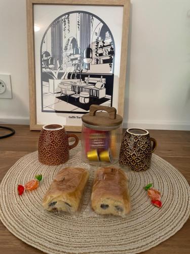 two loaves of bread sitting on a plate with two cups at Chez Carla in Sisteron