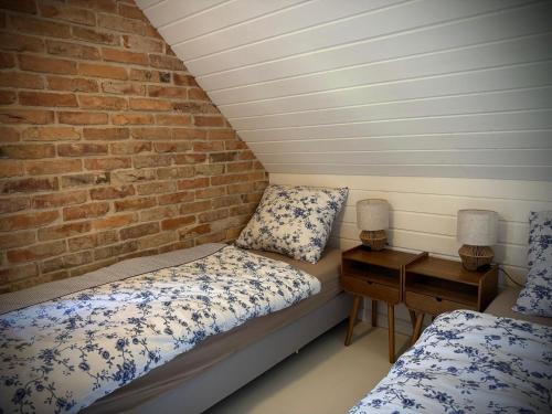 a room with two beds and a brick wall at Siedlisko Na Szlaku Odry 