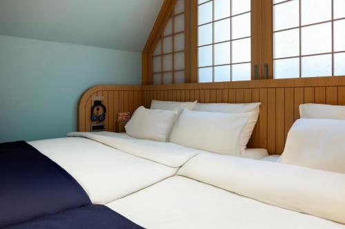 two beds in a room with two windows at Stay Passport Airplane Guri in Guri
