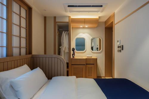 a small bedroom with a bed and a bathroom at Stay Passport Airplane Guri in Guri