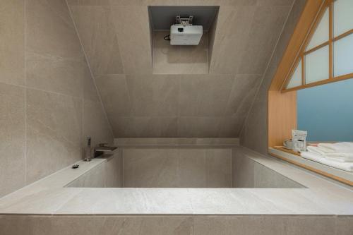 a bathroom with a bath tub with a window at Stay Passport Airplane Guri in Guri