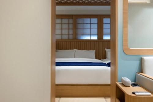 a bedroom with a bed with a wooden door at Stay Passport Airplane Guri in Guri