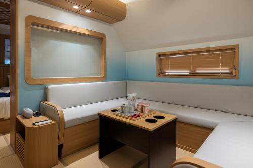 a small room with a bed and a table at Stay Passport Airplane Guri in Guri