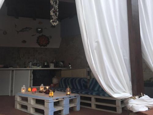 a living room with a couch and a white curtain at Villa oasi in Fontane Bianche
