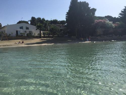 a body of water with a beach and a house at Villa oasi in Fontane Bianche