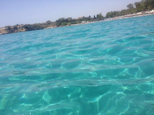 a large body of water with a beach in the background at Villa oasi in Fontane Bianche