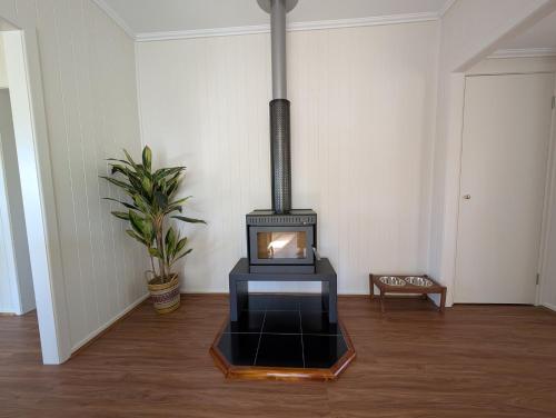 a living room with a stove in the middle of a room at Big Tree Farmhouse in Rathdowney