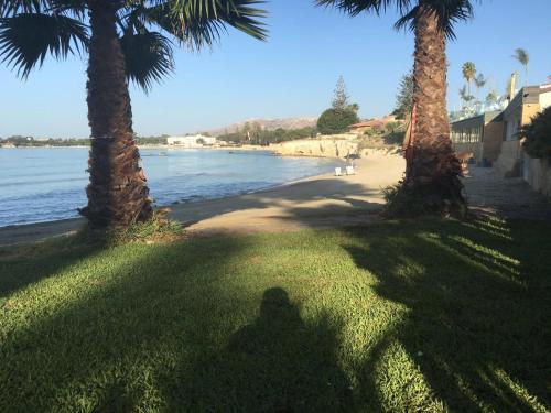 a shadow of a person taking a picture of a beach at Villa oasi in Fontane Bianche