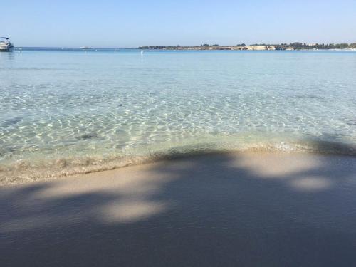 a shadow of a person on a beach in the water at Villa oasi in Fontane Bianche
