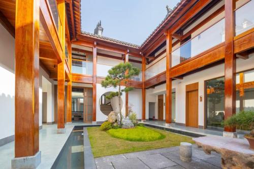池州市にあるHuazhushe Jiuhuashan Suli Zhuyunjian B&Bの中庭の木のある建物の外観