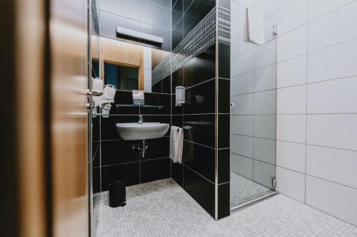a bathroom with a sink and a shower at Coque Hotel in Luxembourg