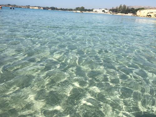 a large body of water with a beach in the background at Villa oasi in Fontane Bianche