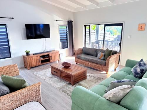 a living room with two couches and a tv at Pool Villa No 10 in Vaimaanga
