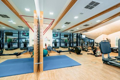 a gym with treadmills and elliptical machines at Coque Hotel in Luxembourg