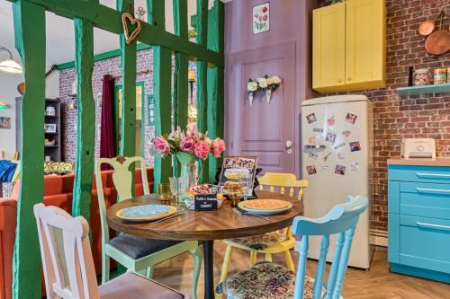 Appartement Friends في رووين: مطبخ به طاولة وكراسي وثلاجة