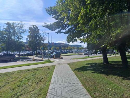 a sidewalk in a park next to a parking lot at Kauno street apartaments in Klaipėda