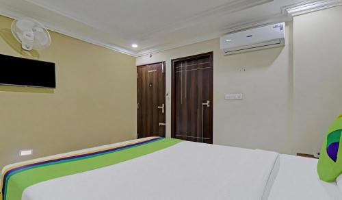 a bedroom with a bed and a flat screen tv at RG SUITES Koramangala in Bengaluru
