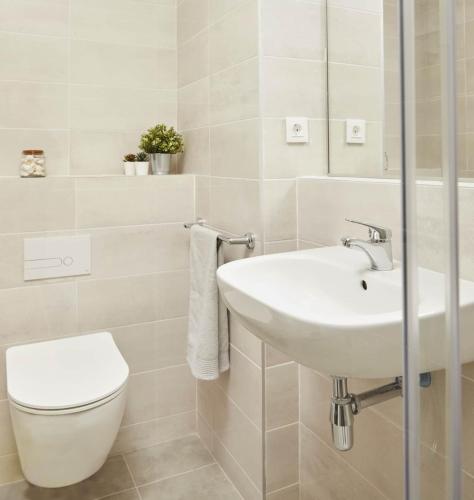 a white bathroom with a sink and a toilet at Student Experience Madrid Pozuelo - Luxury Hostel in Pozuelo de Alarcón