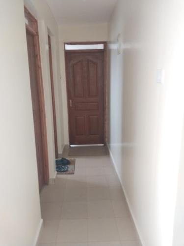 LibweziにあるDoeliam homesの茶色のドアとタイルフロアの廊下