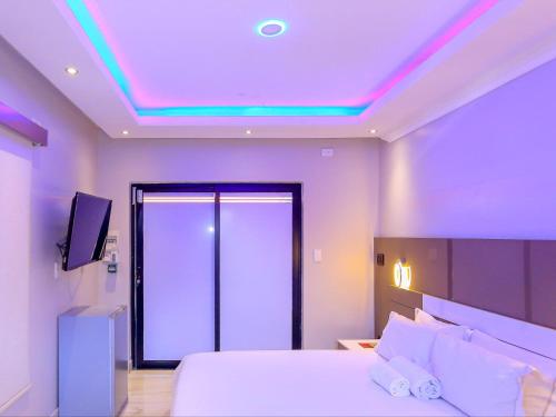 a bedroom with a bed and a tv on the ceiling at Skylight Guest Lodge in Johannesburg