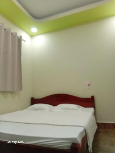 a bedroom with a large bed with white sheets at MOTEL Đồng Khởi in Giồng Tú Ðiền