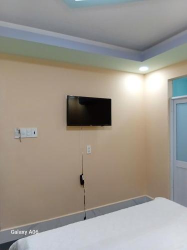 a bedroom with a flat screen tv on the wall at MOTEL Đồng Khởi in Giồng Tú Ðiền