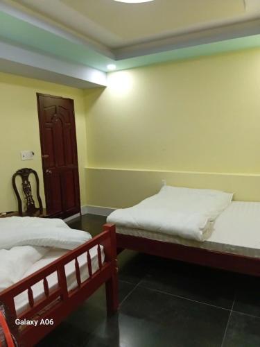 a bedroom with two beds and a door at MOTEL Đồng Khởi in Giồng Tú Ðiền