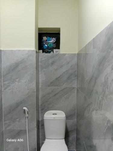 a bathroom with a white toilet in a room at MOTEL Đồng Khởi in Giồng Tú Ðiền