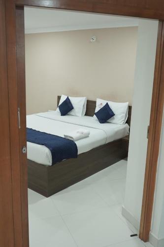 a bed with blue and white pillows on it at Kanishka Grand in Bengaluru