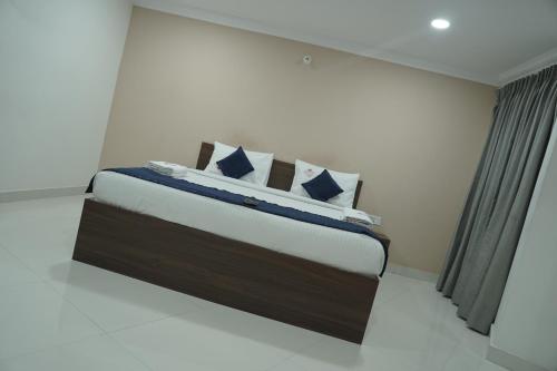 a bedroom with a large bed in a room at Kanishka Grand in Bengaluru