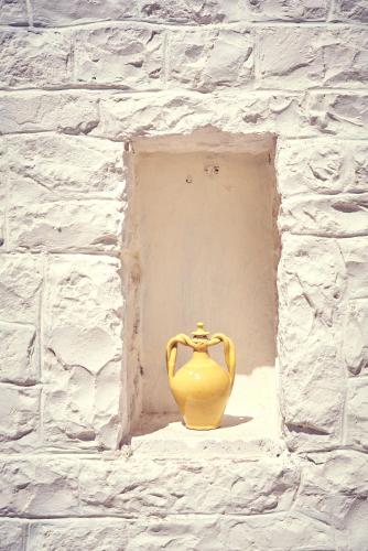 a yellow vase sitting in a niche in a brick wall at Trullo Antonelli in Antonelli