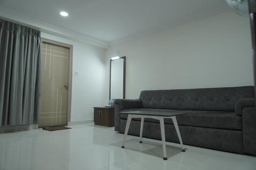 a living room with a couch and a table at Kanishka Grand in Bengaluru