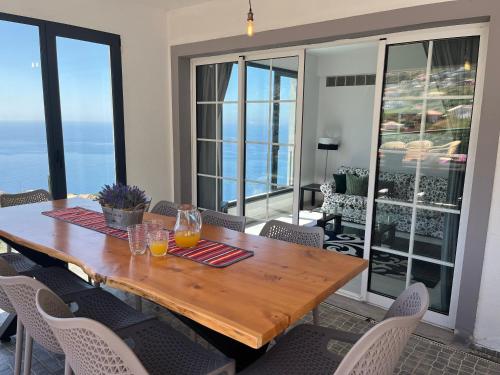 a dining room table and chairs with a view of the ocean at Casa Vista do Ledo in Arco da Calheta