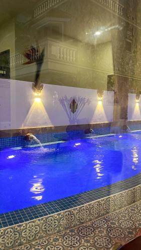a large swimming pool with blue water in a building at Cham Charm Home Mui Ne in Mui Ne