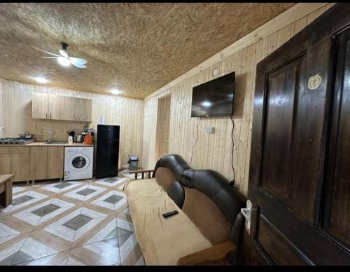 un soggiorno con divano e cucina di Temos cottage a Borjomi