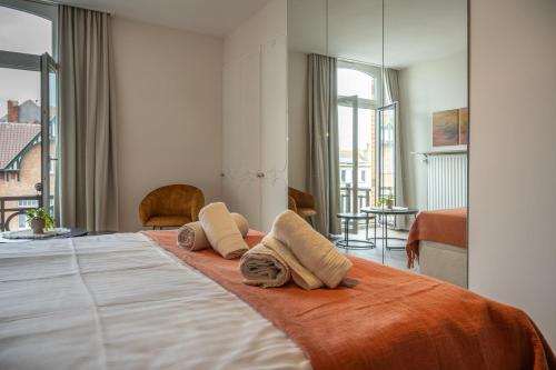 a hotel room with a bed with towels on it at Au Louvre De Haan in De Haan