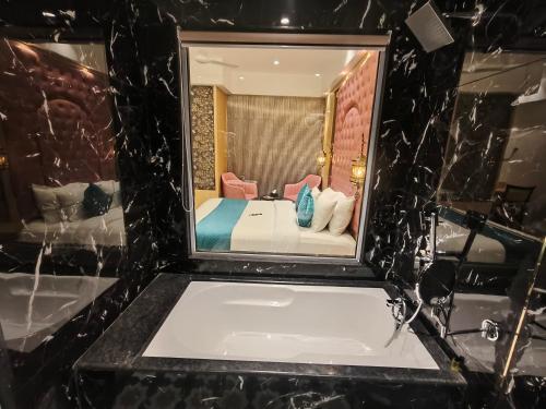 a bathroom with a tub and a bed in a room at Hotel Ocean Residency Thane West in Thane