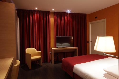 a hotel room with a bed and a television at Best Western Hotel Piemontese in Bergamo