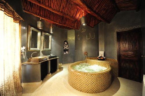 bagno con vasca e lavandino di Kasbah Hotel Tombouctou a Merzouga